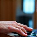 María, una estudiante senior sonriente, tocando el piano con confianza en un aula de Ferros Note.