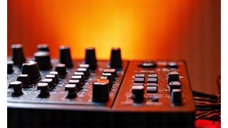 Mezclador de DJ y auriculares con luces de neón en un estudio oscuro